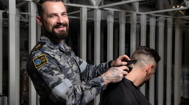 Chief Petty Officer Jessie McFarland runs a barbershop for charity on board HMAS Adelaide. Story by Flying Officer Brent Moloney. Photo by Leading Seaman Sittichai Sakonpoonpol.