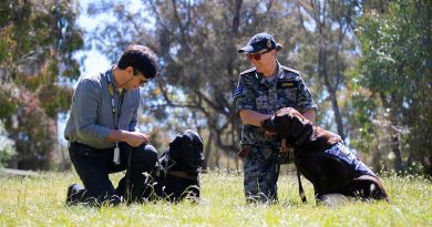 Scott Grimley with his guide dog, Dudley, and Able Seaman Taryn Dickens with her assistance dog, Gigi, enjoy some time in the sun. Story and photo by Private Nicholas Marquis.