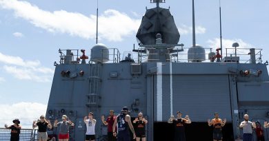 HMAS Arunta personnel conduct a warm up before the Teddy Sheean, VC, Commemorative Workout. Story and photo by Leading Seaman Susan Mossop.