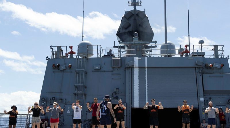 HMAS Arunta personnel conduct a warm up before the Teddy Sheean, VC, Commemorative Workout. Story and photo by Leading Seaman Susan Mossop.