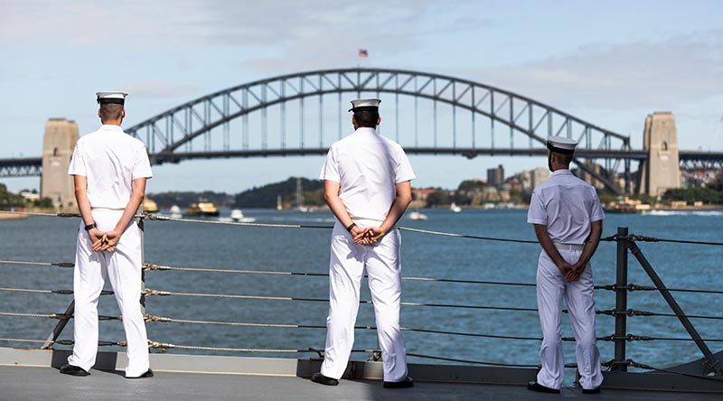 HMAS Hobart sailors line the deck as the ship sails into Sydney Harbour – home in time for Christmas.