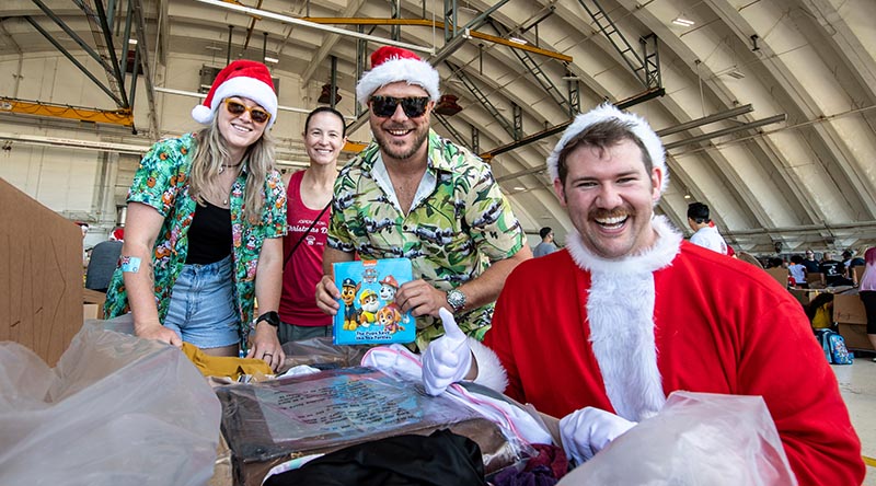 Corporal Maddison Graham, RAAF; Lieutenant Colonel Kira Coffey, PACAF; Sergeant Ben Rhodes, RAAF; and Captain Andrew Zaldibar, PACAF put the finishing touches to a load during Operation Christmas Drop's Bundle Build Day. Photo by Sergeant Vanessa Parker.