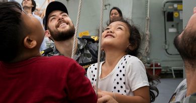 Lieutenant Quaelan Brooks helps children from the Khlong Toey slum raise communication flags on HMAS Anzac during a port visit to Bangkok in 2018. Story by Corporal Michael Rogers. Photo by Petty Officer Kayla Jackson.