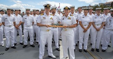 Outgoing Commanding Officer HMAS Hobart Captain Andrew Pepper, front left, hands the “weight of command” to the incoming Commanding Officer Commander Tina Brown. Story by Lieutenant Stacey Butters. Photo by Petty Officer Christopher Szumlanski.