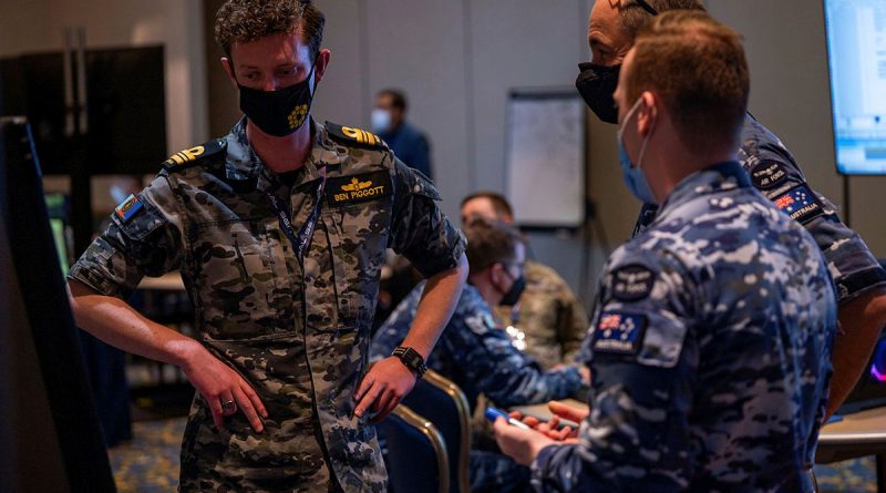 Lieutenant Commander Benjamin Piggott from Defence Space Command talking with other ADF team members on Exercise Global Sentinel 22 in California. Story by Corporal Michael Rogers.