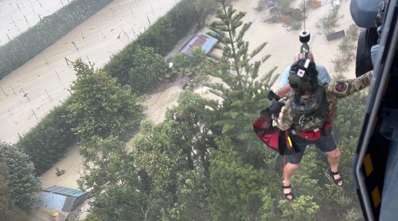 A Royal New Zealand Air Force NH-90 helicopter hoists one of many Kiwis from a rooftop surrounded by floodwaters caused by Cyclone Gabrielle. NZDF photo.