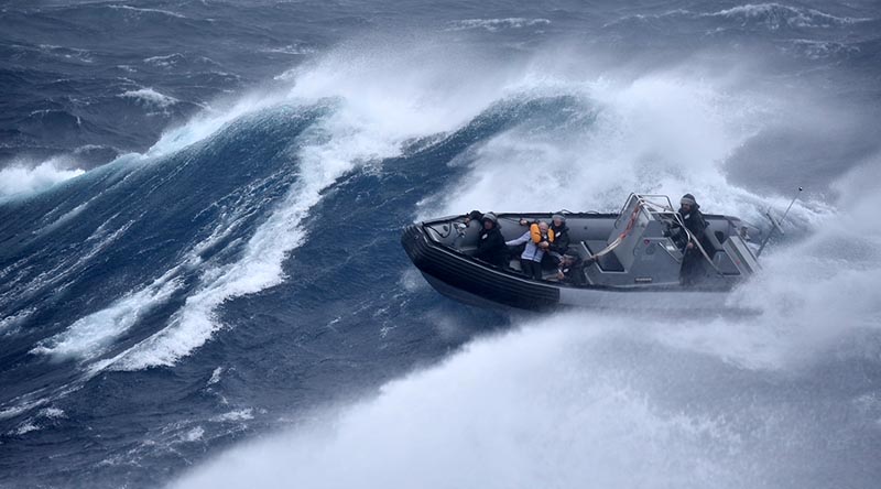 Royal New Zealand sailors from HMNZS Te Mana bring a rescued sailor back to their ship during Cyclone Gabrielle. NZDF photo.