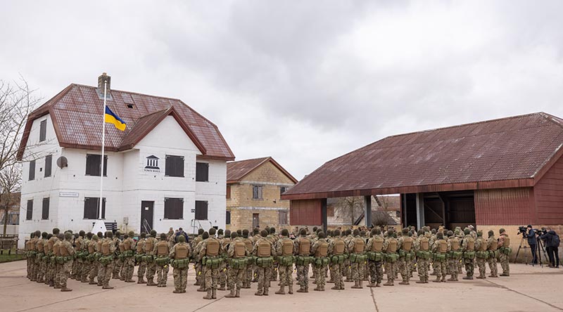 Ukrainian recruits gather to commemorate the year anniversary of the full-scale Russian invasion of Ukraine at a urban training facility in the United Kingdom. Image has been altered for security purposes. Photo by Corporal Jonathan Goedhart.