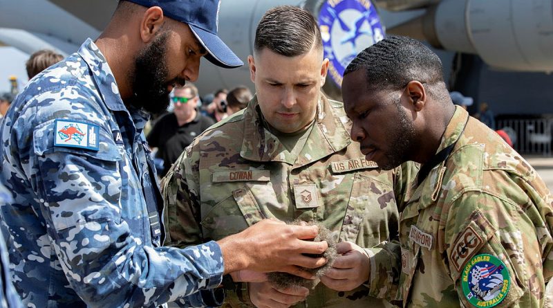 Royal Australian Air Force Indigenous Liaison Officer, Flight Lieutenant Micheal Naawi promotes cultural awareness to Master Sergeant Jonathan Cowan (middle) and Master Sergeant Marcello Lindo of the United States Air Force during the Australian International Airshow 2023 at Avalon. Story by Flying Officer Shan Arachchi Galappatthy. Photo: Leading Aircraftwoman Kate Czerny.