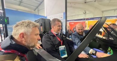 News presenter and Air Force Reservist Wing Commander Peter Overton, centre, with Simon Hobbs, left, testing a flight simulator at Avalon Air Show. Photo by Alex Given.