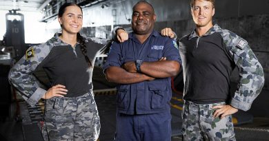 From left, Leading Seaman Sevanna Tansey, Vanuatu Police Maritime Senior Inspector and Executive Officer Gary Aru and Able Seaman Sean Davies stand by the well deck of HMAS Canberra during Operation Vanuatu Assist. Story by Lieutenant Geoff Long. Photo by Leading Seaman Matthew Lyall.