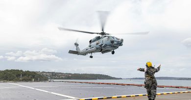 HMAS Choules' flight deck marshaller directs an MH-60R helicopter to the flight deck. Story by Petty Officer Helen Frank. Photo by Able Seaman jasmine Moody.