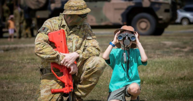 Private Wayne Drage shows a child how to use binoculars during a demonstration at Exercise Rocky Ready, at the Rockhampton Showgrounds last year. Story by Sergeant Matthew Bickerton. Photo by Corporal Madhur Chitnis.