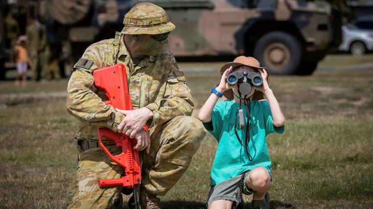 Private Wayne Drage shows a child how to use binoculars during a demonstration at Exercise Rocky Ready, at the Rockhampton Showgrounds last year. Story by Sergeant Matthew Bickerton. Photo by Corporal Madhur Chitnis.