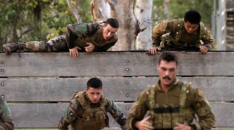 An Australian Army gunner from the 4th Regiment, Royal Australian Artillery and a French Army soldier scale the six-foot wall during a military skills competition as part of Mission Jeanne d'Arc held at Lavarack Barracks, Townsville, Queensland. Photo by Lance Corporal Riley Blennerhassett.