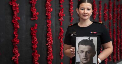 Royal Australian Navy officer Sub Lieutenant Mary Booth holds a portrait of her great uncle Able Seaman Ernest Albert Booth, at the Australian War Memorial in Canberra. Photo by Corporal Luke Bellman.