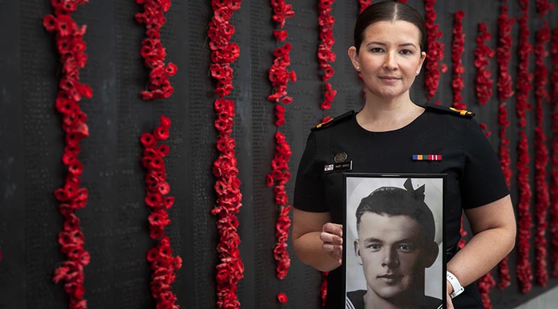 Royal Australian Navy officer Sub Lieutenant Mary Booth holds a portrait of her great uncle Able Seaman Ernest Albert Booth, at the Australian War Memorial in Canberra. Photo by Corporal Luke Bellman.