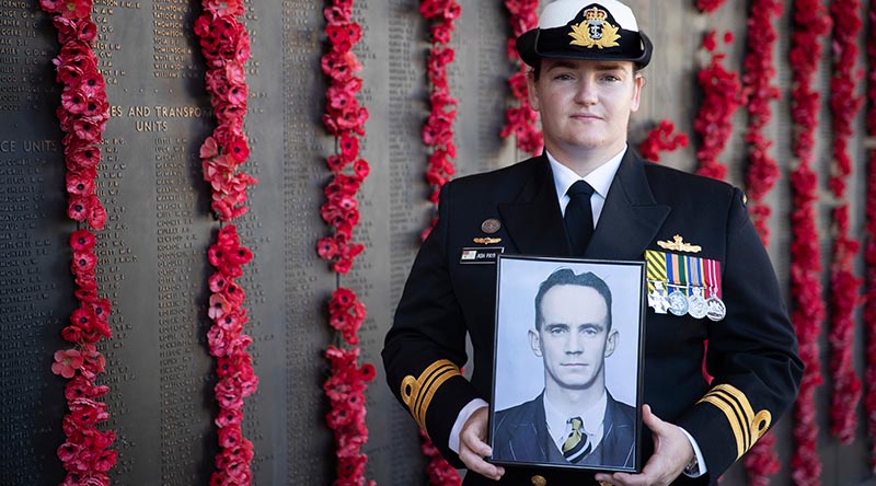 Lieutenant Commander Ashleigh Payne holds a picture of her great-uncle Leading Aircraftman James Geoffrey Payne in front of the Roll of Honour at the Australian War Memorial. Photo by Corporal Michael Rogers.