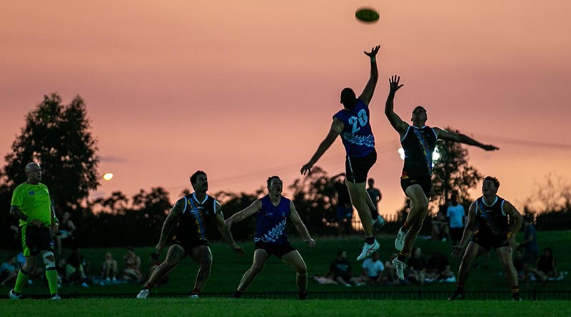 Players from the men's ADF and NT PFES teams vie for the ball during the ANZAC Shield charity AFL match at TIO Stadium, Darwin, NT. Photo by Signalman Kobi Rankin.