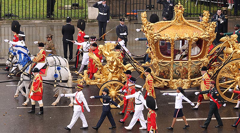 Their Majesties The King and Queen travel past Parliament Square in the Gold State Coach, flanked by 18 representatives of the Commonwealth, including Royal Australian Air Force Corporal Tegan Ross and Bombardier Michael Nona from Australia’s Federation Guard (second in line on both sides). Photo by AS1 Ryan Murray RAF. UK MOD © Crown copyright 2023.
