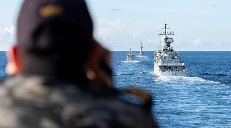 HMAS Anzac's Lieutenant Christopher Colalillo takes ranges during Officer of the Watch Manoeuvres with Republic of Singapore Navy RSS Vigliance (centre) Royal Malaysian Navy KD Lekir (right) and KD Gempita (left) during Exercise Bersama Shield 23. Photo by Leading Seaman Jarryd Capper.