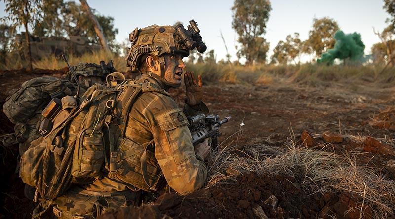 A 3RAR soldier gives orders during an assault on the enemy's main defensive position. Photo by Lance Corporal Riley Blennerhassett.
