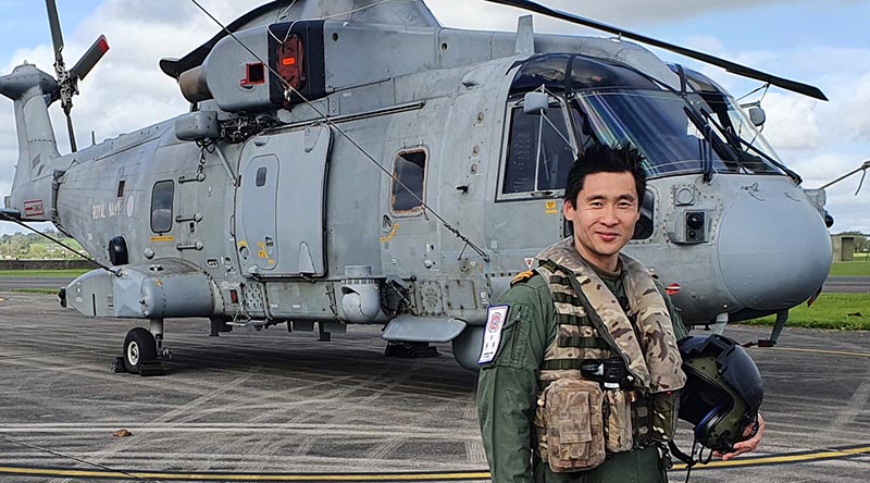 Lieutenant Daniel Cochrane with the Merlin HM2 he flies on exchange with Royal Navy 820 Squadron in the United Kingdom.