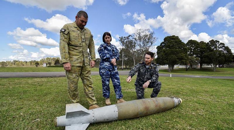 Combat engineer Sergeant Kieron Day, armament technician Corporal Bethany Magner and clearance diver Chief Petty Officer Ben Beck discuss unexploded ordnance. Photo by Corporal Randall Costello