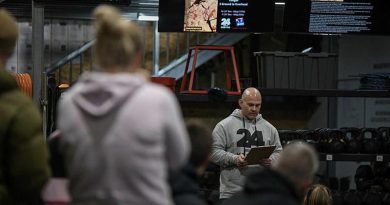 Warrant Officer Class 2 Beau Thomas reads the biography of a fallen soldier before another workout begins at the 24 Hours of Heroes fundraiser for Wounded Heroes. Photo by TrewBella Photography.