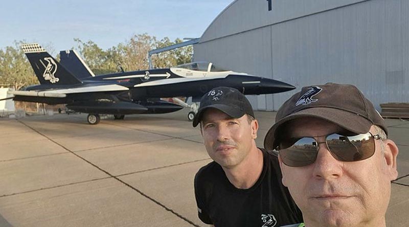 Surface finishers Sergeant Steve Marshall and Leading Aircraftman Macdara Barden in front of an F/A-18A Hornet A21-018, from 75 Squadron, with a commemorative paint scheme at RAAF Base Tindal, Northern Territory.