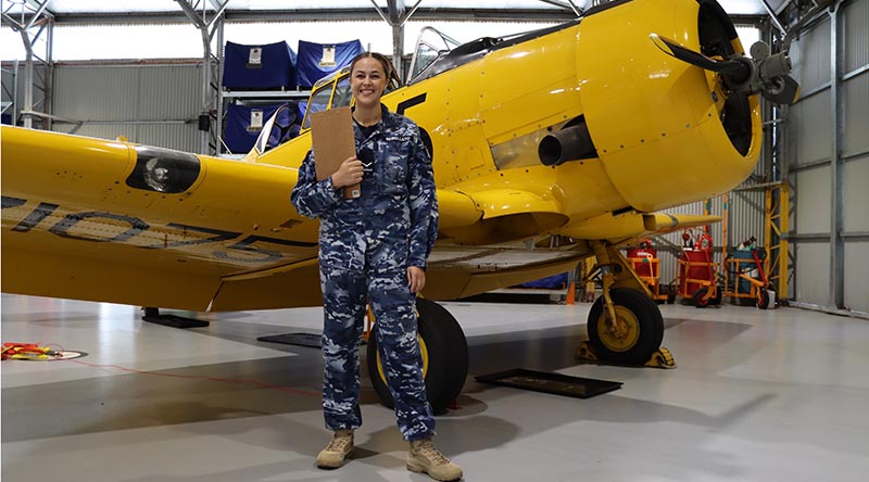 Personnel Capability Specialist at No. 100 Squadron Leading Aircraftwoman Casey-Lee Rebellato in front of a Harvard aircraft at RAAF Base Point Cook. Photo by David Jones.