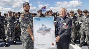 Commanding Officer HMAS Toowoomba Commander Darin MacDonald, left, receives a painting gift from the Western Australian Naval Association President Ian Holthouse during a clear lower deck on board the ship at HMAS Stirling. Photo: Leading Seaman Ernesto Sanchez