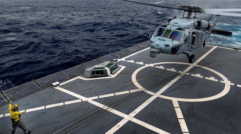 USS America's MH-60S helicopter is marshalled by HMAS Anzac’s Leading Seaman Joshua Leach during deck landing training on board Anzac. Story by Lieutenant Max Logan. All photos by Leading Seaman Jarryd Capper.