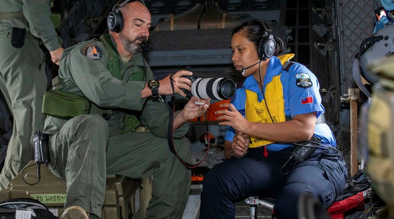 Loadmaster Flight Sergeant Christian Allison of 35 Squadron teaches Samoan police officer Constable Fetuao Nuuvali how to use the camera during Operation Solania. Photos by Leading Aircraftman Chris Tsakisiris.