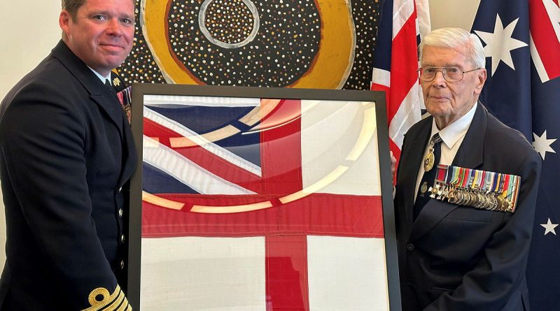 Rear Admiral (retd) Guy Griffiths, right, presents the Royal Navy ensign to Commanding Officer HMS Prince of Wales Captain Richard Hewitt. Story by Lieutenant Charlie Marshall.