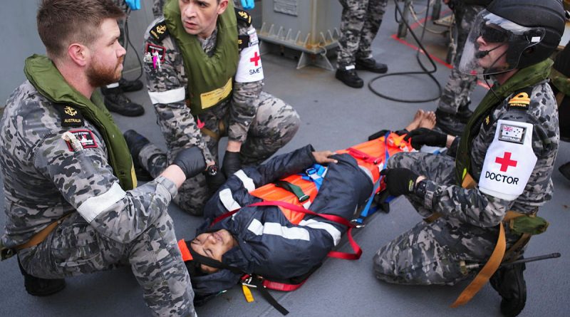 Leading Seaman Ryan Feenan, Leading Seaman Aaron Evans and medical officer Lieutenant Jarrad Blackburn provide care to an injured mariner aboard an oil tanker during a medical evacuation in the Southern Indian Ocean. Story by Lieutenant Max Logan. Photo by Tyson Burraston.