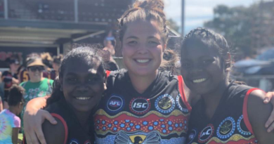 Ms Amber Alexander (centre) on the footy field. Story by Emily Egan.