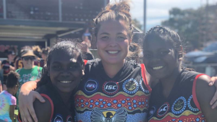 Ms Amber Alexander (centre) on the footy field. Story by Emily Egan.