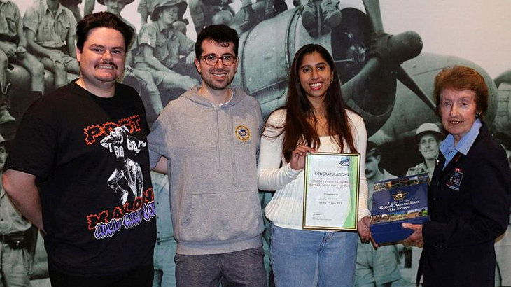 Wagga Aviation Heritage Centre volunteer Christine Wyatt presents Erika Mendes with a certificate and book set, while Kieren Johnston and Haig Vartoukian look on. Story by Flight Lieutenant Karyn Markwell. Photo by Peter Wyatt.