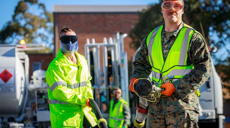 RAAF aviation refueller, Leading Aircraftman Stephen Gannon (L) instructs US Marine Corps refuellers on the operation of Australian refuelling trucks at RAAF Base Williamtown, NSW. Story by Flight Lieutenant Claire Campbell. Photo by Corporal Craig Barrett.