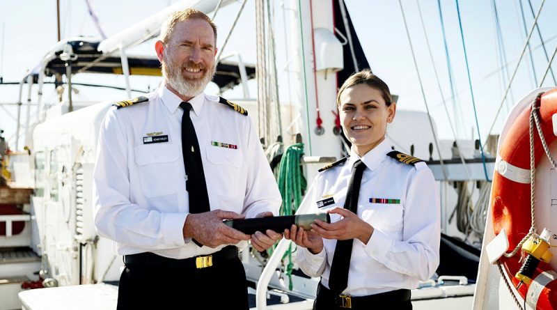 Departing Commanding Officer Sail Training Ship Young Endeavour, Lieutenant Commander Adam Farley, left, hands over the 'Weight' to incoming Commanding Officer Lieutenant Commander Elizabeth Newman. Story by Eliza Jay. Photos by Leading Seaman David Cox.