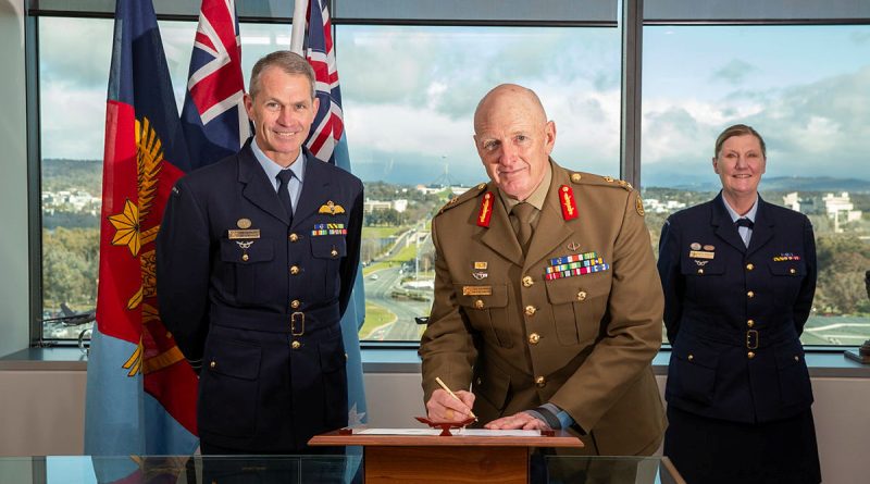 Chief of Joint Capabilities Lieutenant General John Frewen signs the change in command of Space Command document in front of Chief of Air Force Air Marshal Robert Chipman and Commander Defence Space Command Air Vice Marshal Cath Roberts. Story by Peter O'Rourke. Photo by Sergeant Rodney Welch.