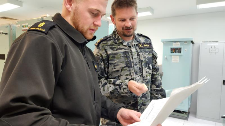 Lead communications technician instructor Petty Officer Christopher Smyth instructs Able Seaman Caleb Pope in the operation and maintenance of the main broadcast system on an Anzac-class frigate at the Navy Engineering Systems Centre at HMAS Stirling. Story by Richard Wilkins.