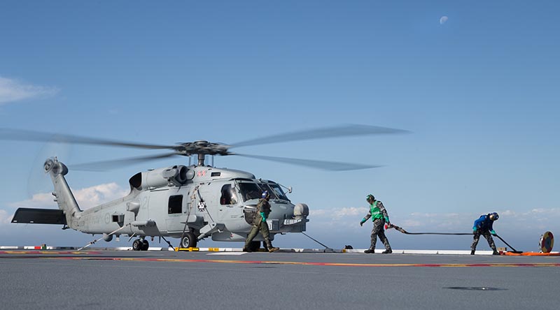 Flight deck crew on HMAS Adelaide 'hot refuel' a running MH-60R Seahawk helicopter during Exercise Ocean Explorer 2017, off the west coast of Australia. Photo by Leading Seaman Peter Thompson.