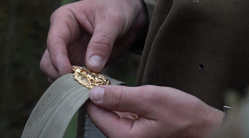 An Australian Army soldier proudly pins his well-earned Skippy badge to his puggaree after completing Exercise Hardcorps at the School of Infantry, Singleton, New South Wales. Photo by Corporal Shane Kelly.