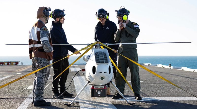 S100 crew from 822X Squadron and Defence Science and Technology Group personnel discuss the S100 bathymetric LiDAR sensor trials on the flight deck of HMAS Adelaide during Exercise Sea Raider. Story by Corporal Luke Bellman. Photo by Able Seaman Rikki-Lea Phillips.