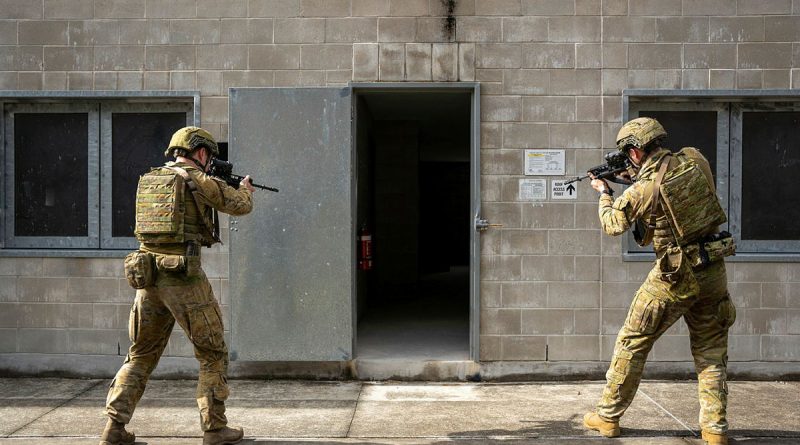 From left, Army soldiers Lance Corporal Timothy Maloney and Private Liam McIvor, from the 9th Battalion, Royal Queensland Regiment, prepare to enter a building during joint training activities at Gallipoli Barracks, Queensland. Story and photo by Private Connor Morrison.