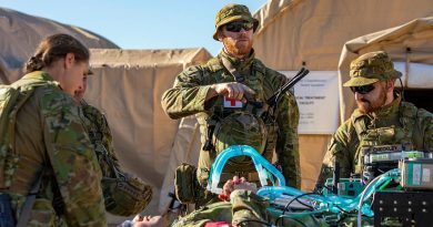 RAAF Medical technician Corporal Brett Leddy from 1 Expeditionary Health Squadron directs the transport of a patient into the back of a G-Wagon ambulance. Story by Flying Officer Connor Bellhouse. Photo by Leading Aircraftwoman Annika Smit.