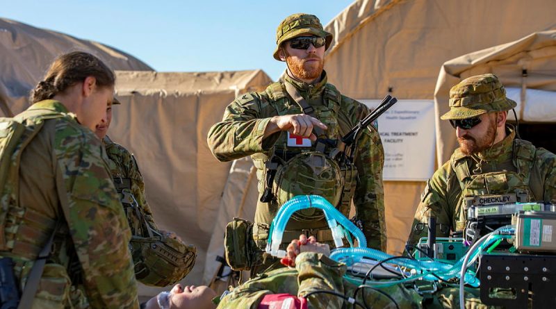 RAAF Medical technician Corporal Brett Leddy from 1 Expeditionary Health Squadron directs the transport of a patient into the back of a G-Wagon ambulance. Story by Flying Officer Connor Bellhouse. Photo by Leading Aircraftwoman Annika Smit.