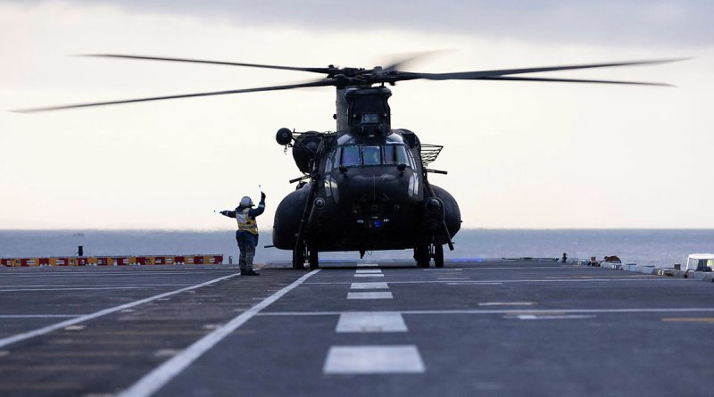 A Royal Australian Navy aviation support sailor marshals a United States Army MH-47G Chinook after it landed on HMAS Adelaide during Exercise Balance Action. Story by Captain Sarah Kelly. Photo by Able Seaman Rikki-Lea Phillips.